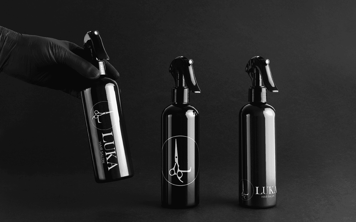 Black spray bottles with the Luka Hair Salon logo